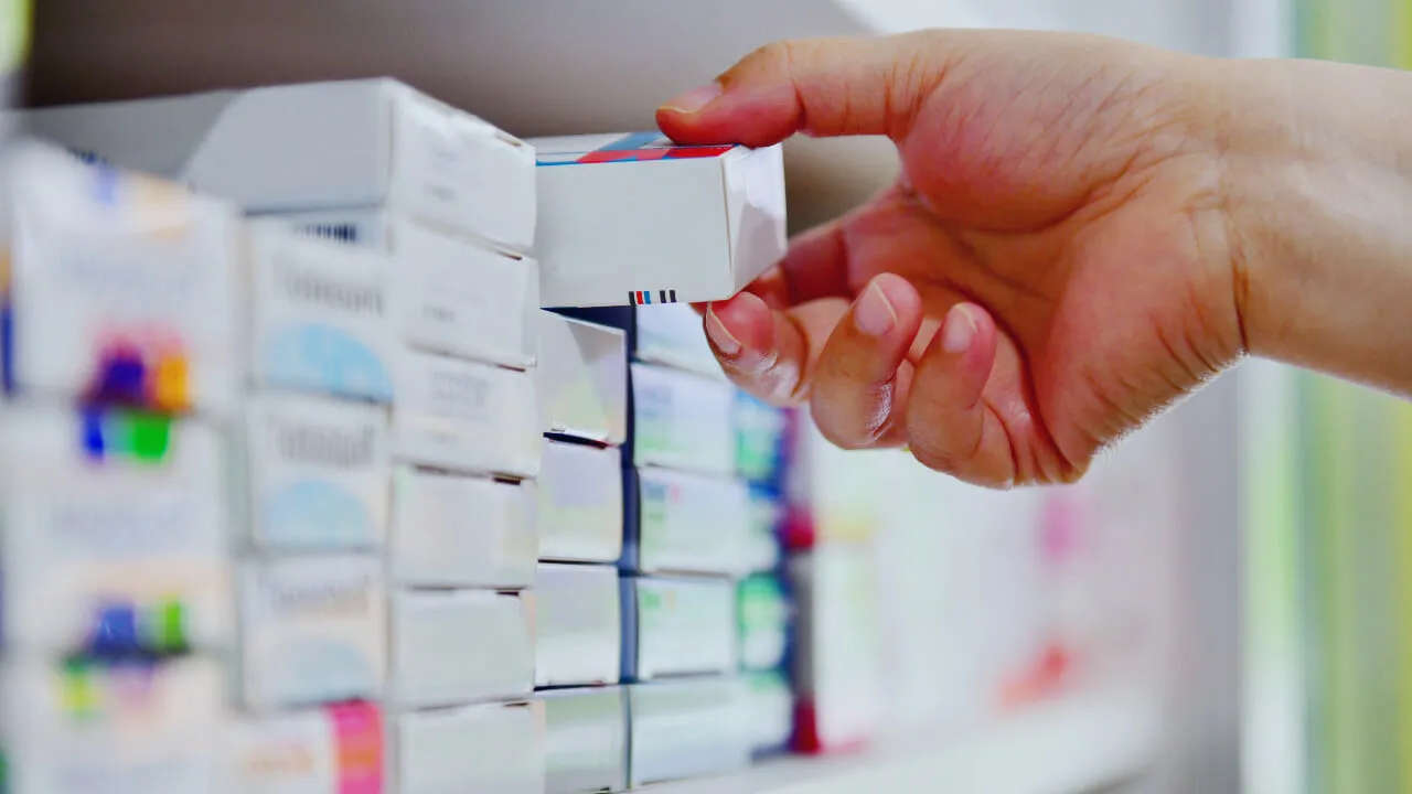 Hand holding medicine in a pharmacy